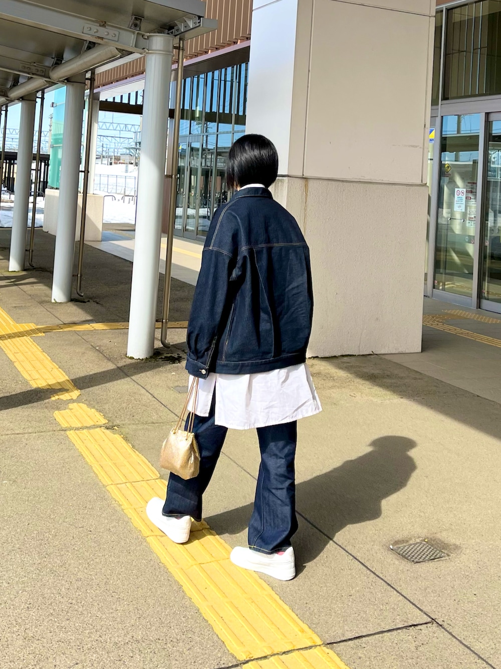 ブルー系のデニムパンツ、ブルー系のデニムジャケット、ホワイト系のシャツ/ブラウスを着用したレディースの春コーディネートの4枚目の写真