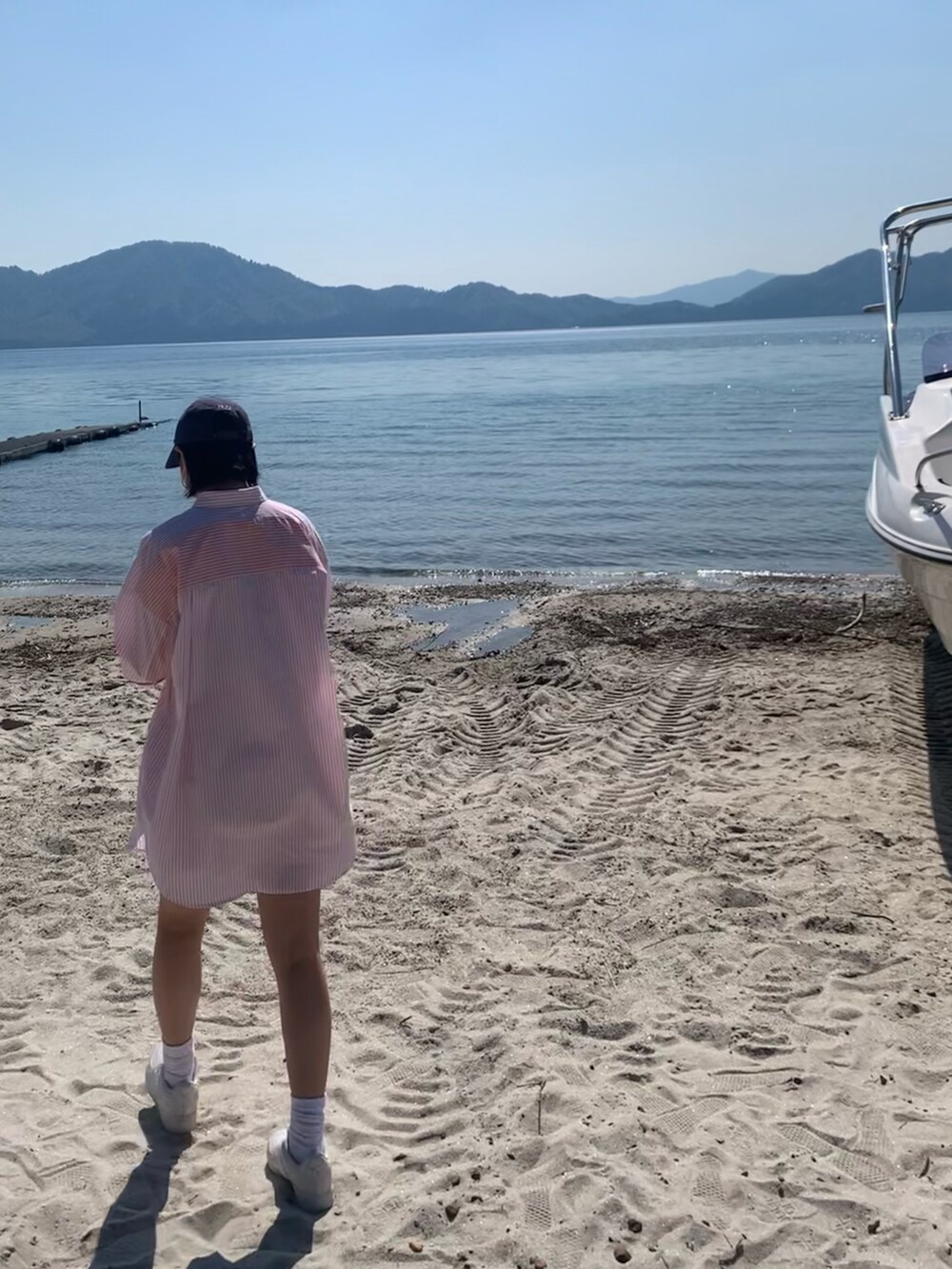 オレンジ系のシャツ/ブラウス、ホワイト系のデニムパンツ、ホワイト系のスニーカーを着用したレディースの春コーディネートの3枚目の写真