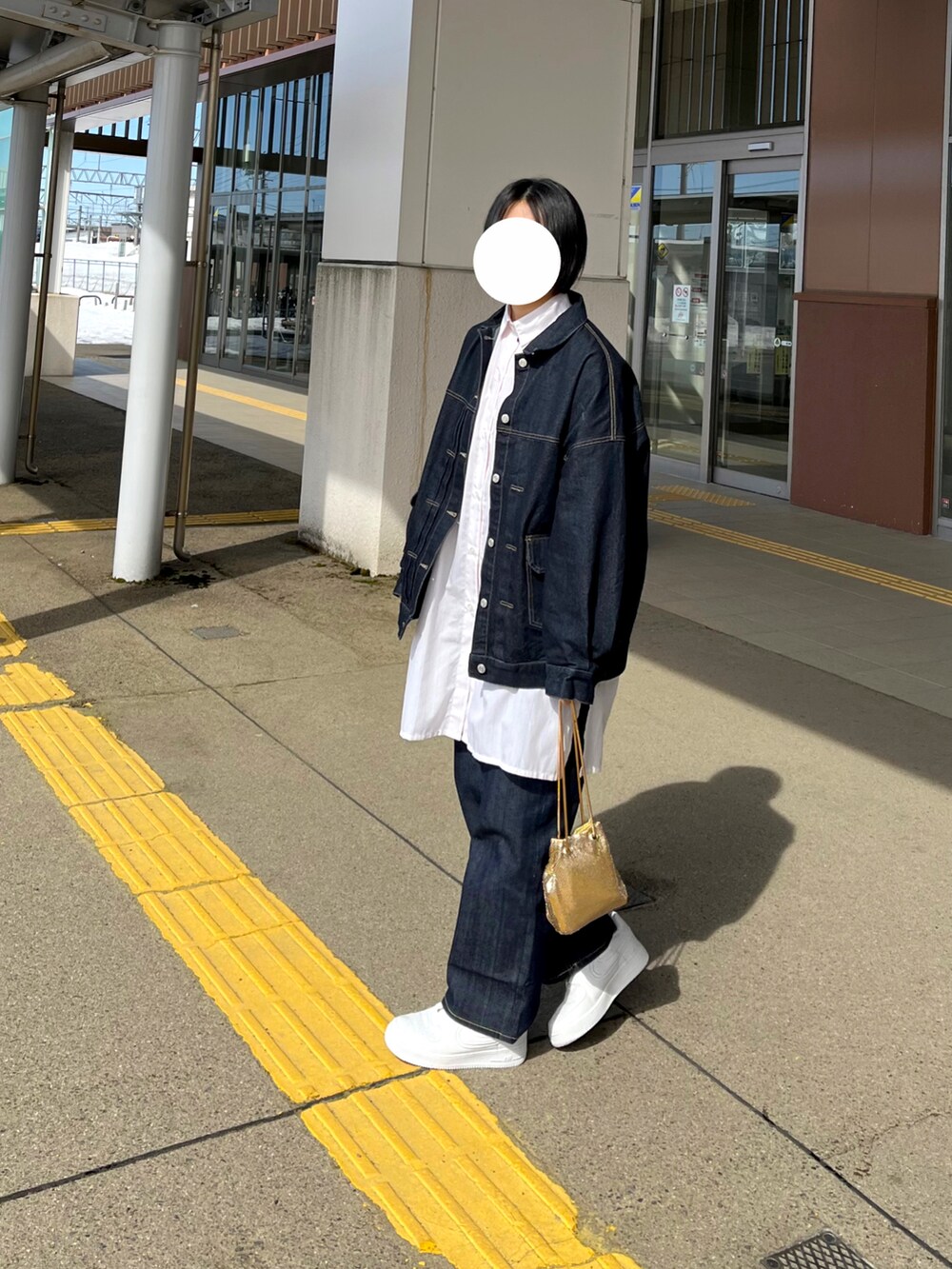 ブルー系のデニムパンツ、ブルー系のデニムジャケット、ホワイト系のシャツ/ブラウスを着用したレディースの春コーディネートの3枚目の写真