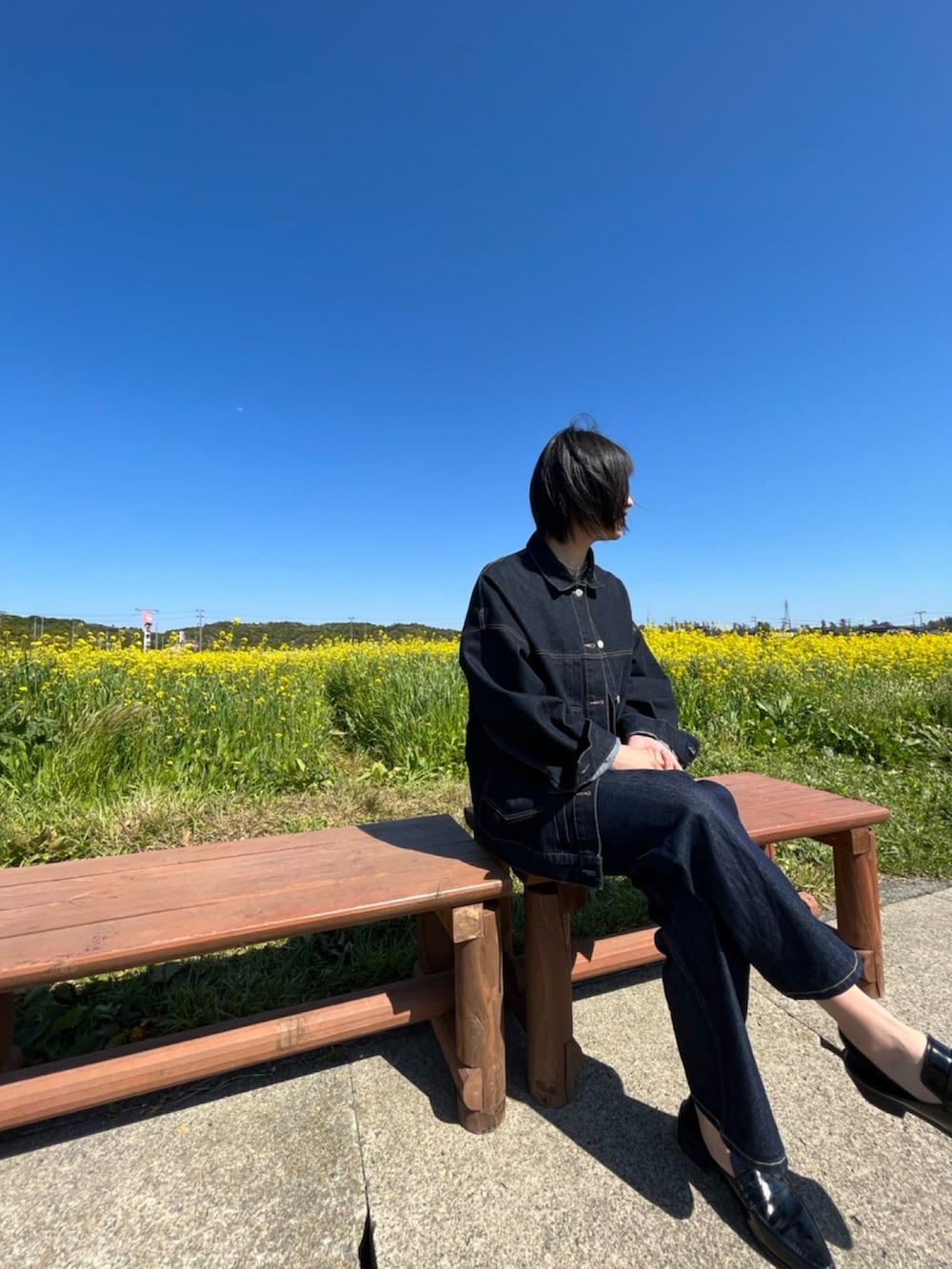 ブルー系のデニムジャケット、グレー系のキャミソール、ブルー系のデニムパンツを着用したレディースの春コーディネートの4枚目の写真