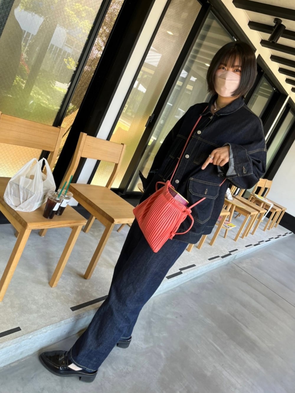 ブルー系のデニムジャケット、グレー系のキャミソール、ブルー系のデニムパンツを着用したレディースの春コーディネートの3枚目の写真