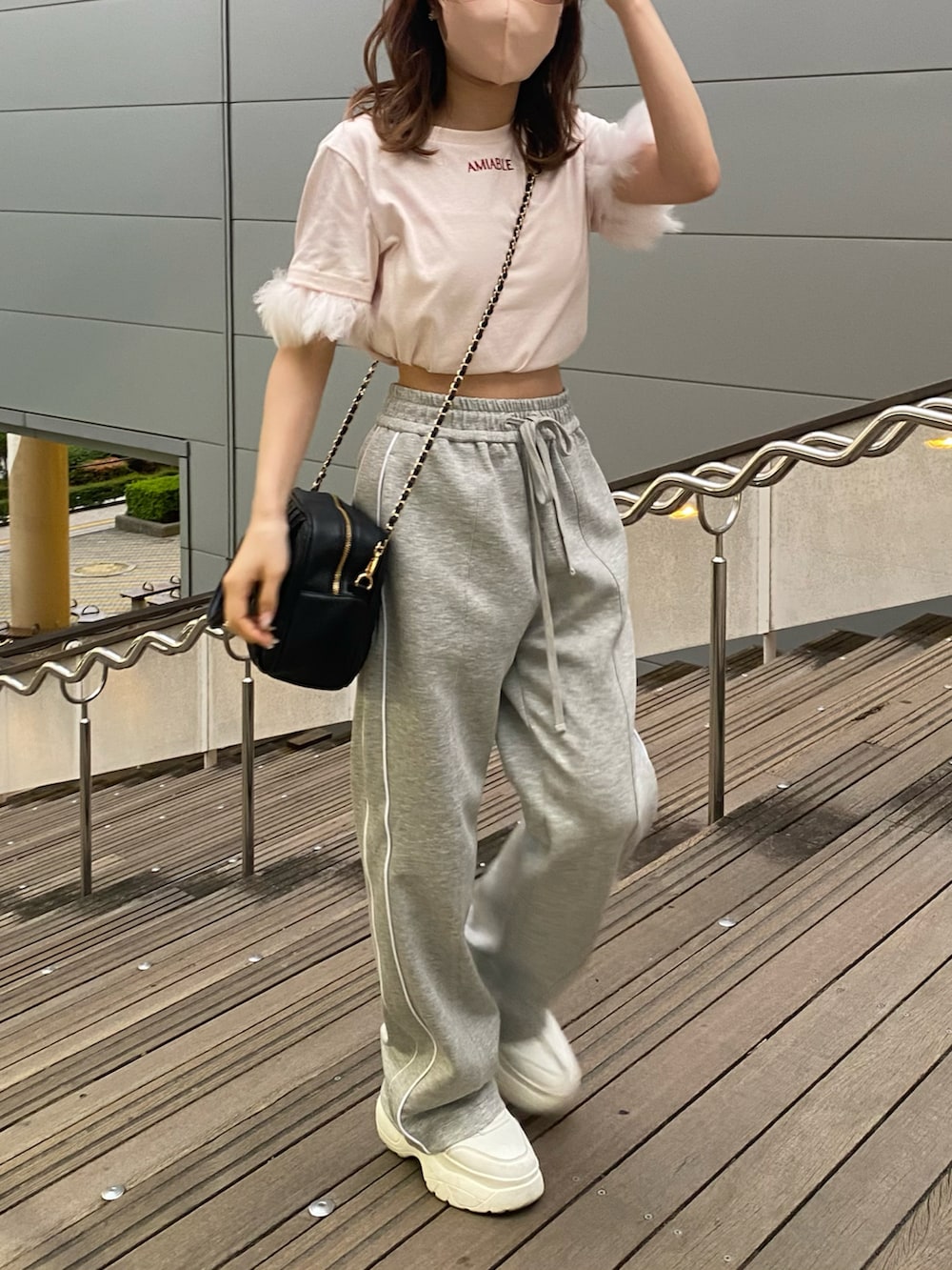 ピンク系のTシャツ/カットソー、ブラック系のボストンバッグ、グレー系のスウェットパンツを着用したレディースの夏コーディネートの2枚目の写真