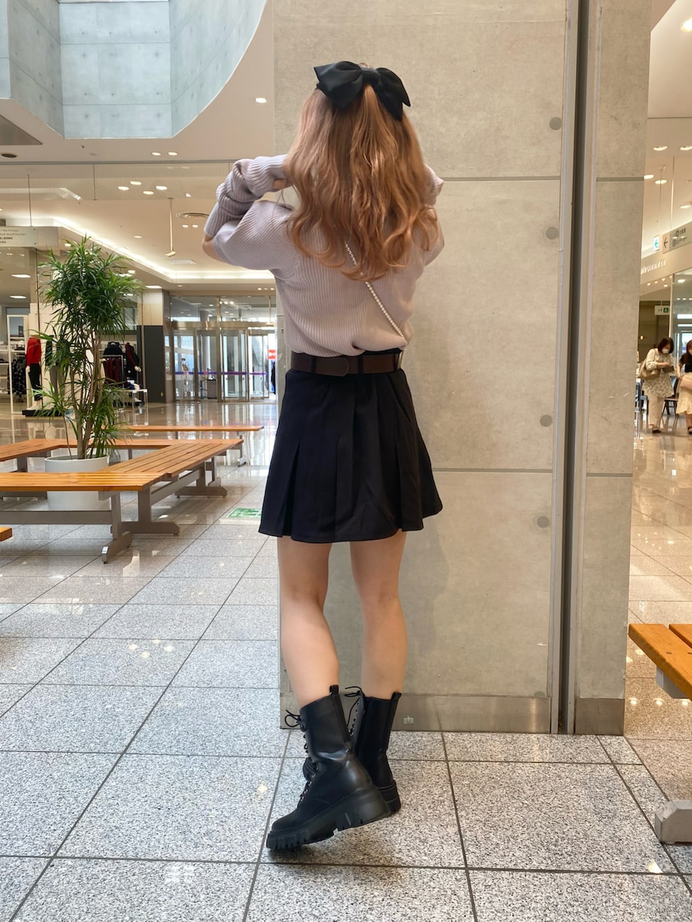 パープル系のニット/セーター、ブラック系のスカート、ブラック系のブーツを着用したレディースの秋コーディネートの3枚目の写真