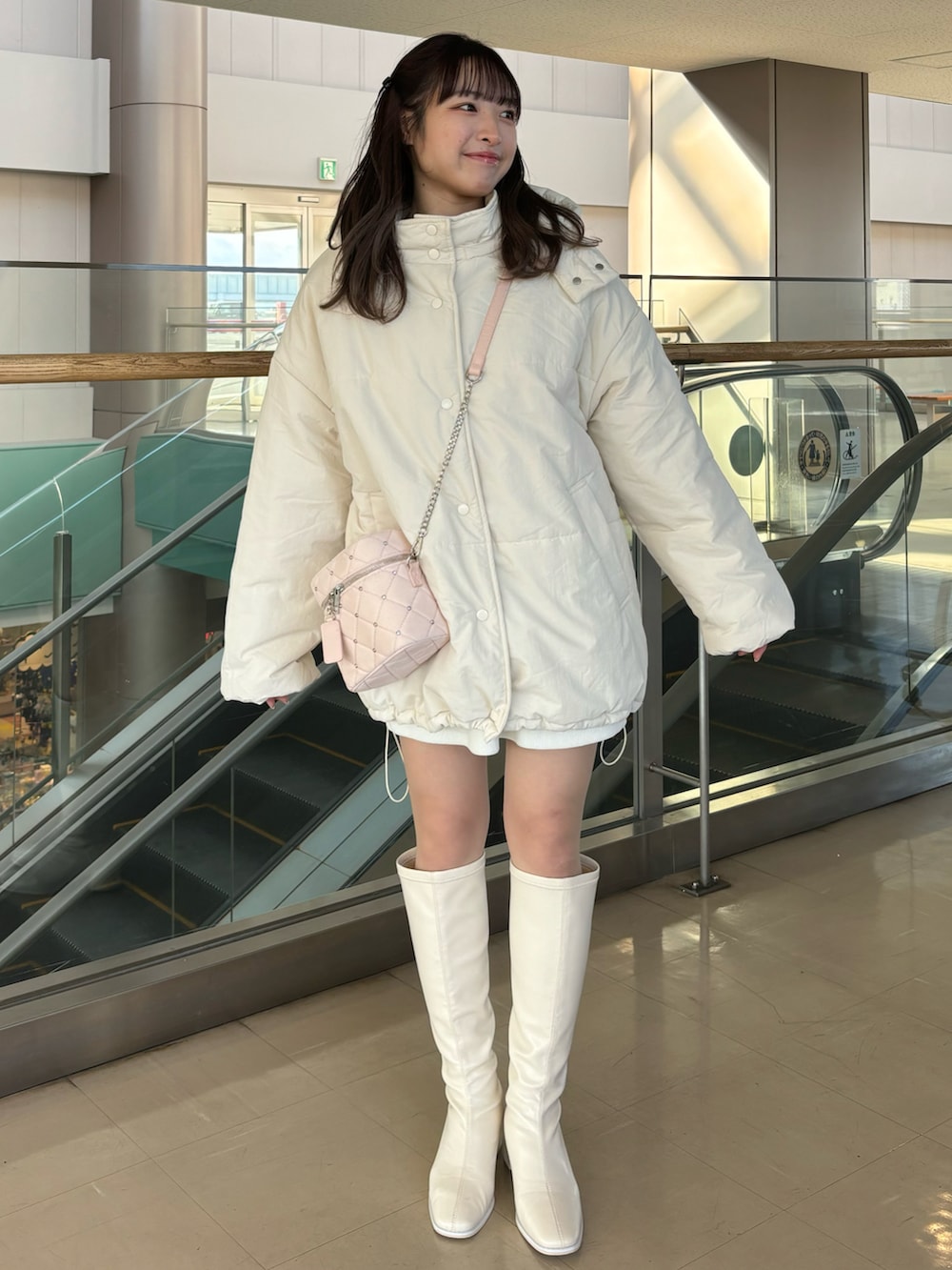 ホワイト系のダウンジャケット/コート、ピンク系のショルダーバッグを着用したレディースの冬コーディネートの2枚目の写真