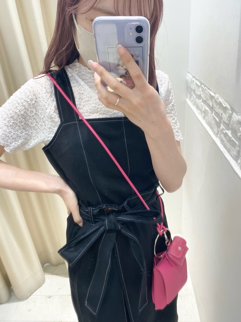 ホワイト系のサンダル、ブラック系のジャンパースカート、ピンク系のショルダーバッグを着用したレディースの夏コーディネートの3枚目の写真