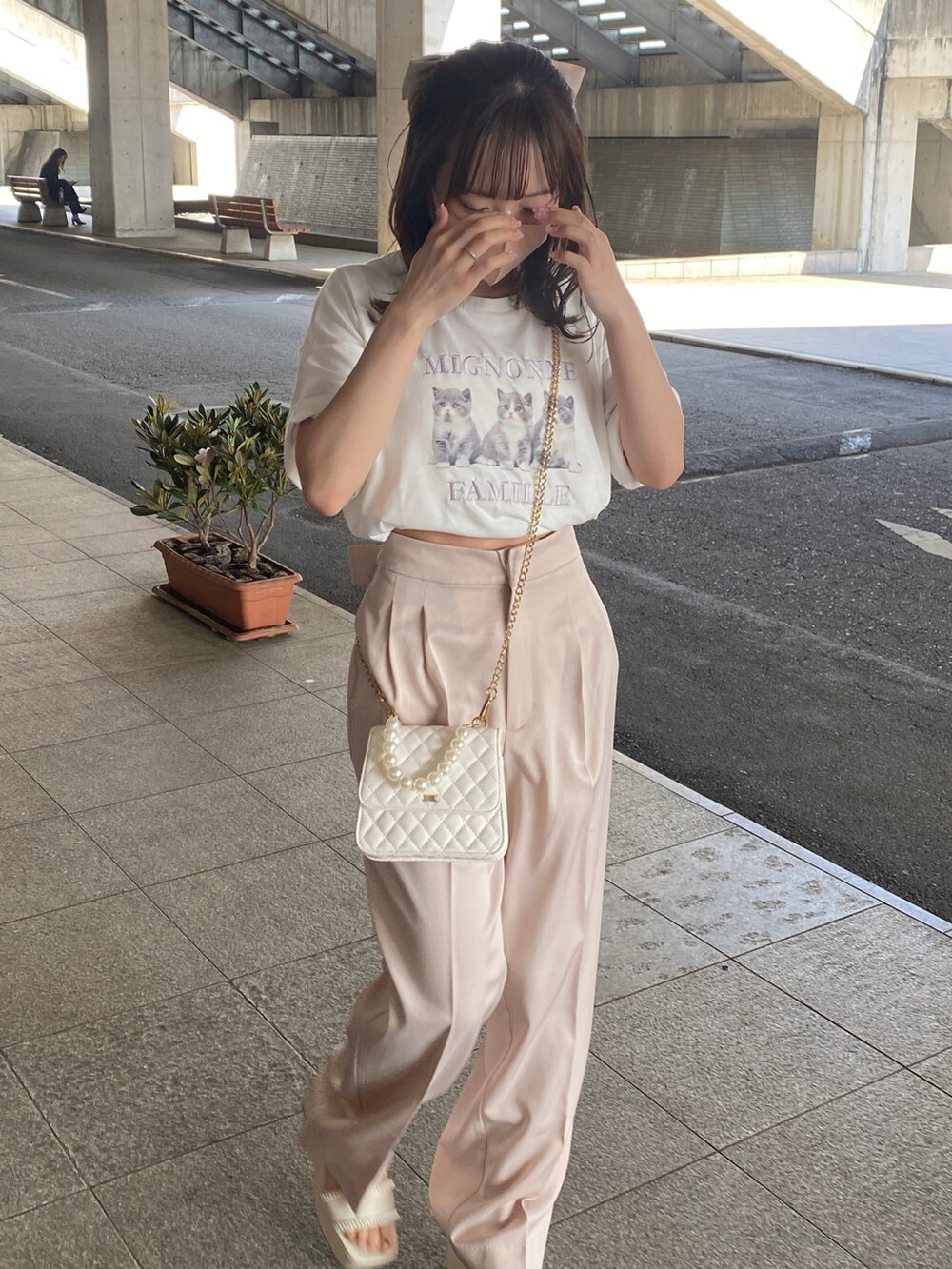 ホワイト系のニット/セーター、ピンク系のスラックス、ホワイト系のTシャツ/カットソーを着用したレディースの春コーディネートの2枚目の写真