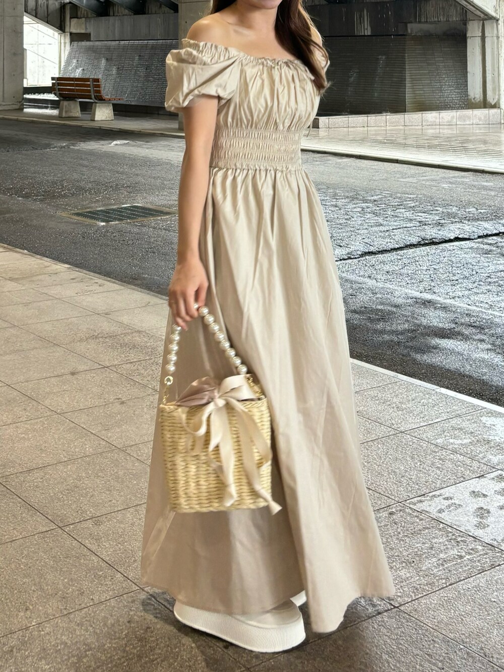 ベージュ系のワンピース、ホワイト系のかごバッグを着用したレディースの春コーディネートの2枚目の写真