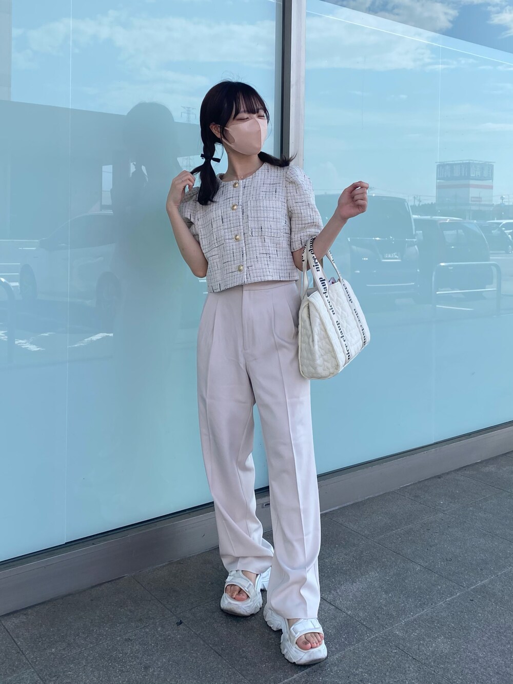 ホワイト系のノーカラージャケット、ホワイト系のスラックス、ホワイト系のトートバッグを着用したレディースの夏コーディネートの2枚目の写真