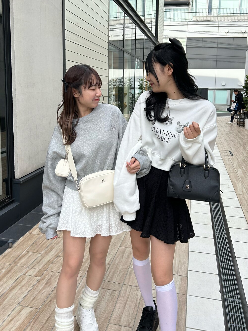 グレー系のトップス、ホワイト系のボディバッグ/ウエストポーチ、ホワイト系のスニーカーを着用したレディースの冬コーディネートの4枚目の写真