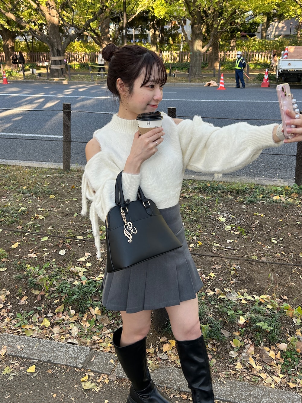 ホワイト系のニット/セーター、グレー系のスカート、ブラック系のブーツを着用したレディースの秋コーディネートの3枚目の写真