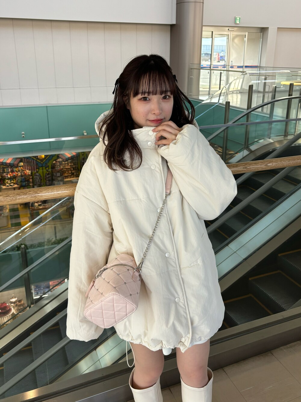 ホワイト系のダウンジャケット/コート、ピンク系のショルダーバッグを着用したレディースの冬コーディネートの3枚目の写真