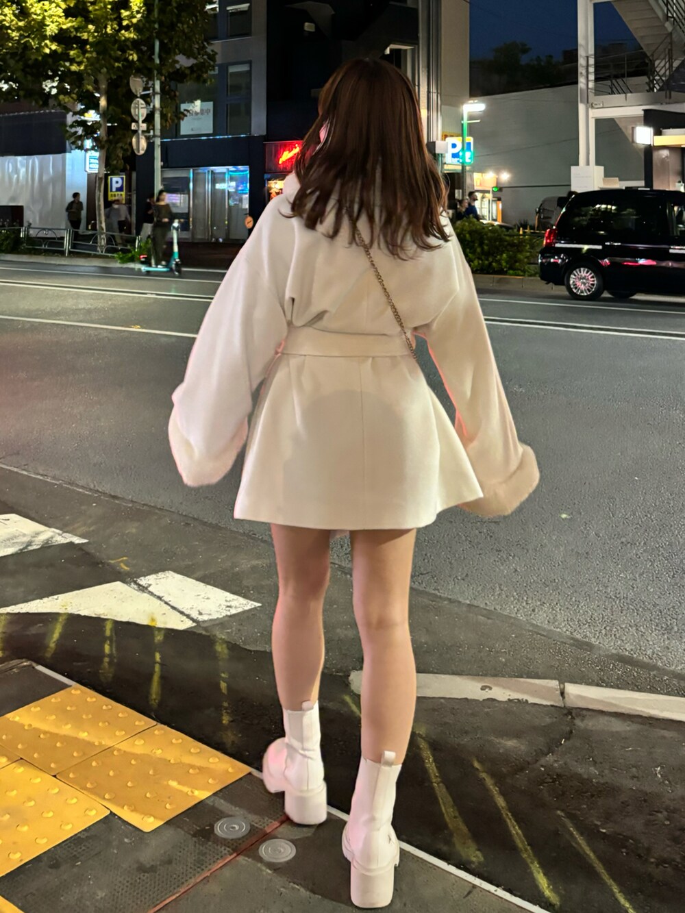 ホワイト系のステンカラーコートを着用したレディースの秋コーディネートの3枚目の写真