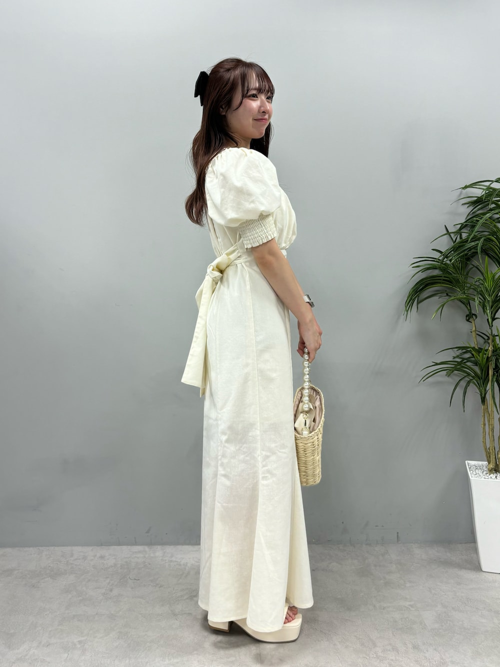 ホワイト系のワンピース、ホワイト系のサンダル、ホワイト系のかごバッグを着用したレディースの春コーディネートの2枚目の写真