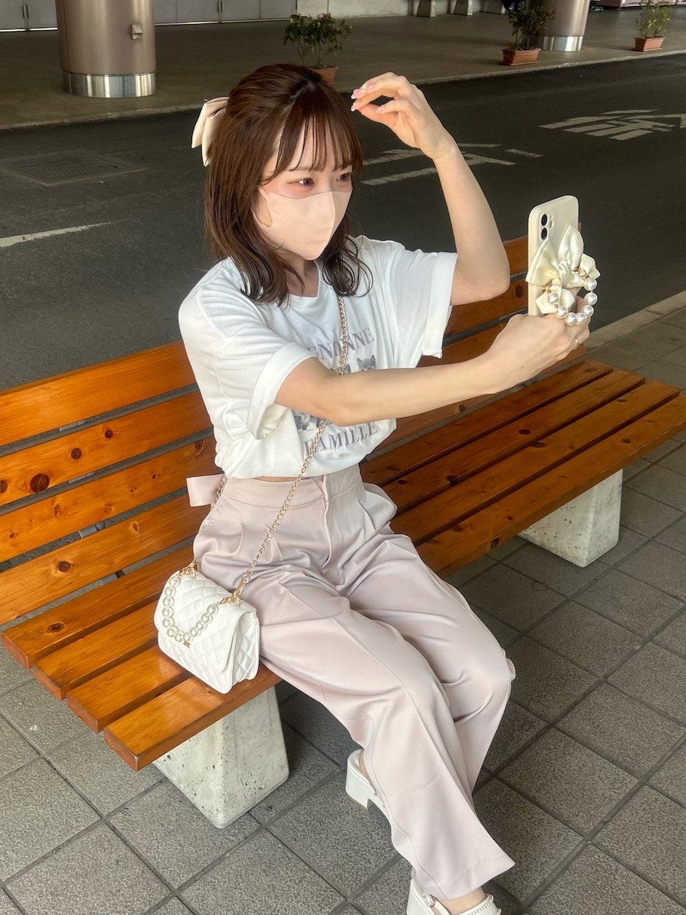 ホワイト系のニット/セーター、ピンク系のスラックス、ホワイト系のTシャツ/カットソーを着用したレディースの春コーディネートの3枚目の写真