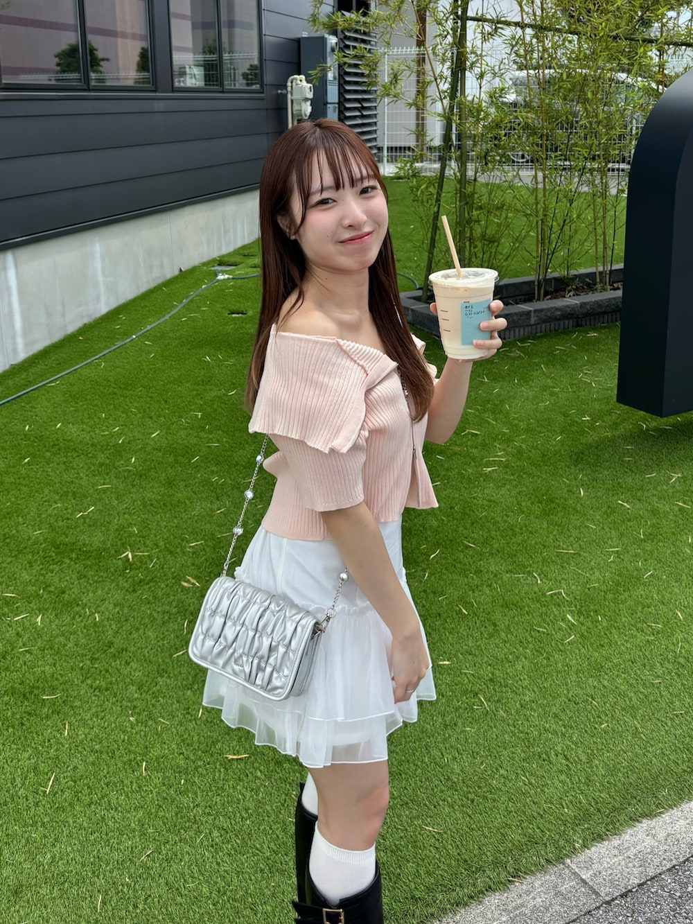 ピンク系のニット/セーター、ホワイト系のスカート、シルバー系のショルダーバッグを着用したレディースの夏コーディネートの4枚目の写真