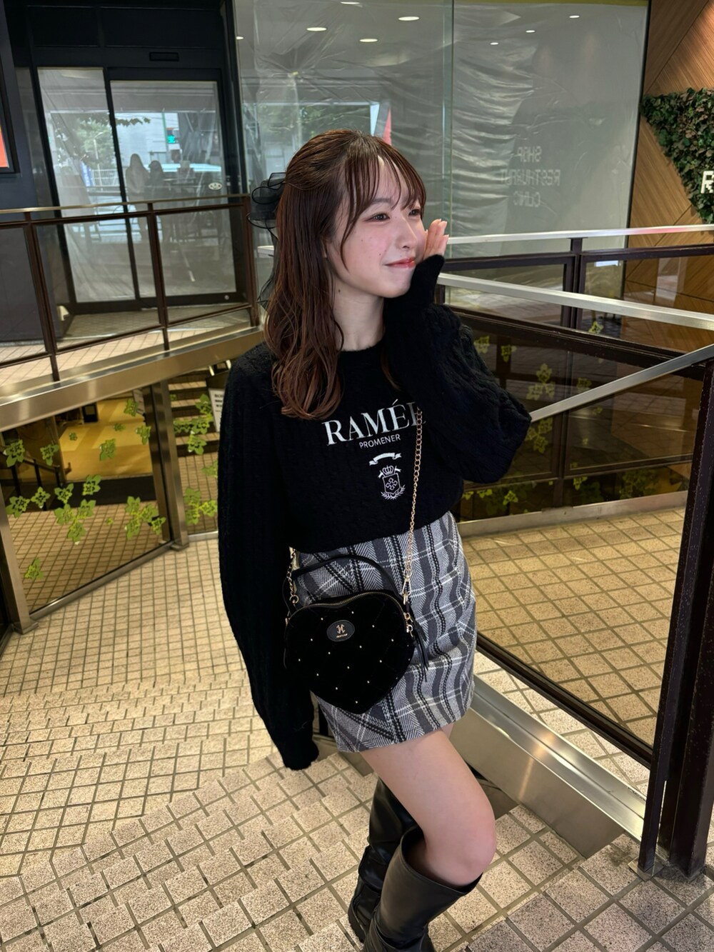 ブラック系のニット/セーター、ブラック系のスカート、ブラック系のショルダーバッグを着用したレディースの秋コーディネートの2枚目の写真