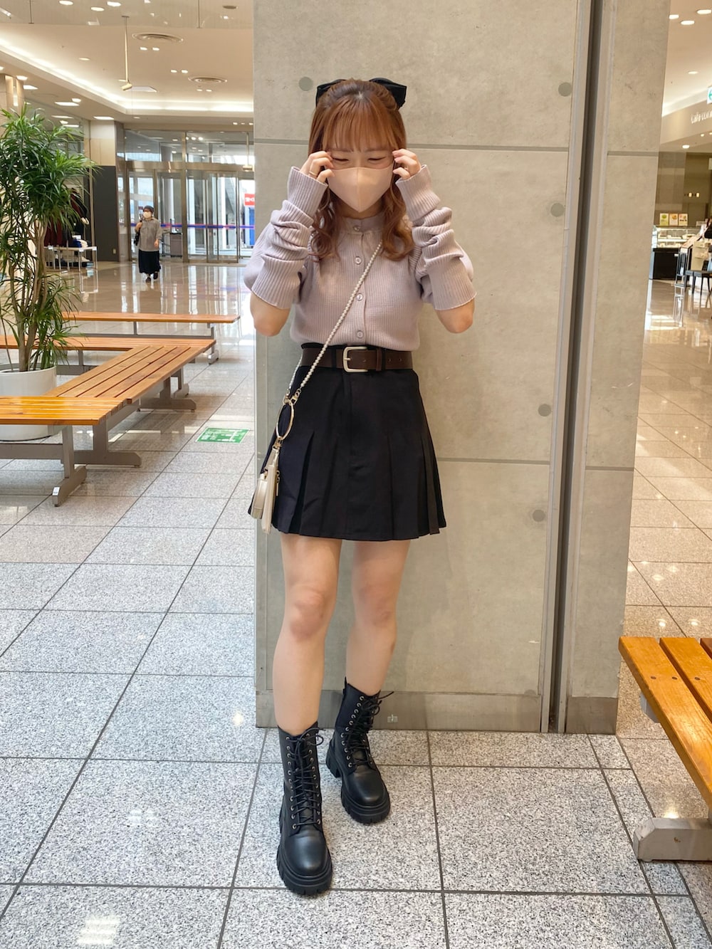 パープル系のニット/セーター、ブラック系のスカート、ブラック系のブーツを着用したレディースの秋コーディネートの2枚目の写真