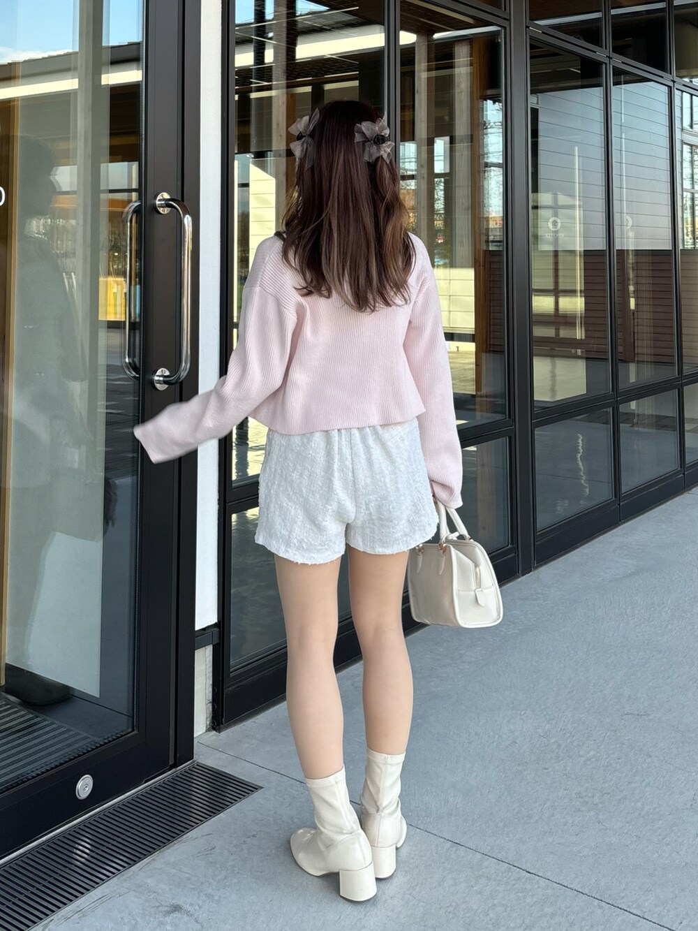 ピンク系のカーディガン/ボレロ、ホワイト系のその他パンツを着用したレディースの冬コーディネートの2枚目の写真