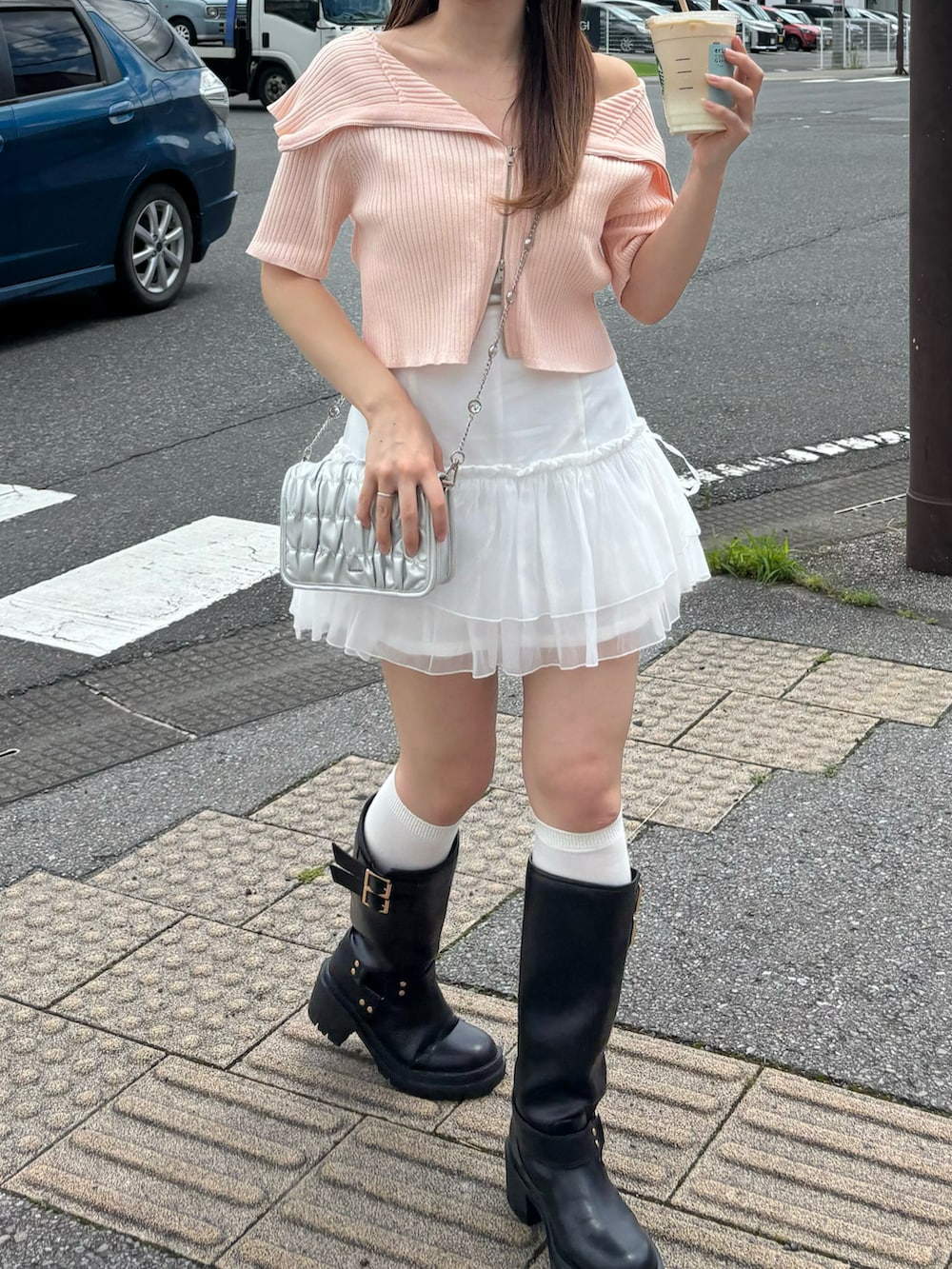 ピンク系のニット/セーター、ホワイト系のスカート、シルバー系のショルダーバッグを着用したレディースの夏コーディネートの2枚目の写真