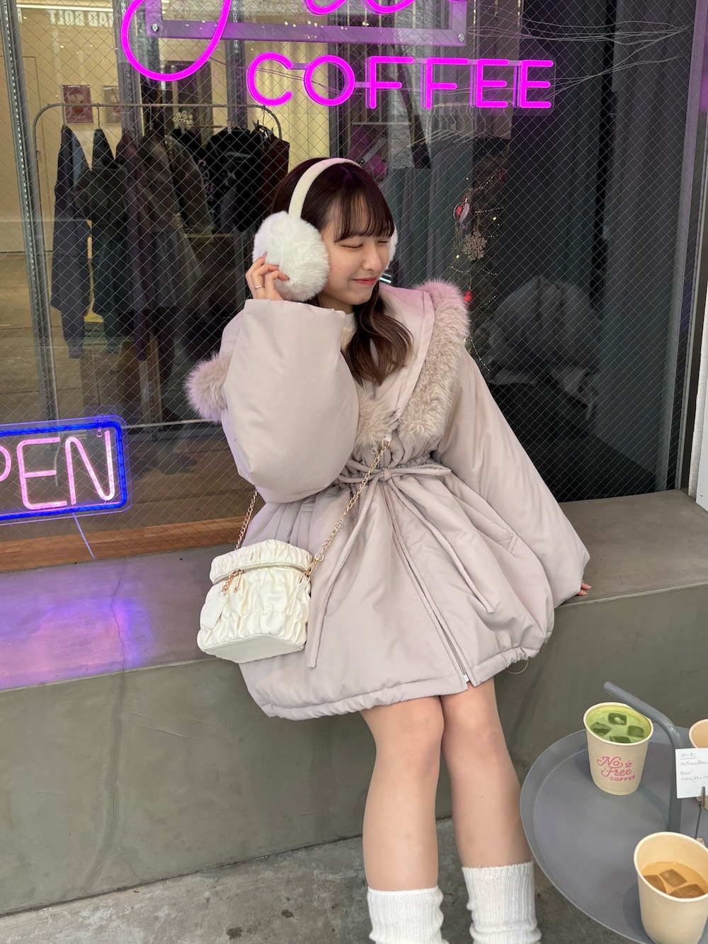 ベージュ系のダウンジャケット/コート、ホワイト系のショルダーバッグを着用したレディースの冬コーディネートの2枚目の写真