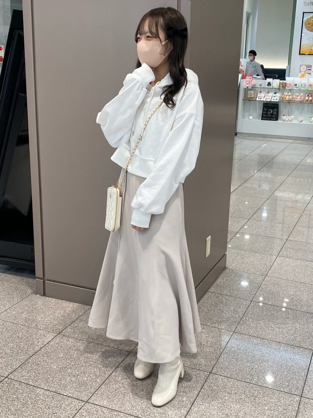 ホワイト系のパーカー、ホワイト系のスカート、ホワイト系のブーツを着用したレディースの秋コーディネートの2枚目の写真