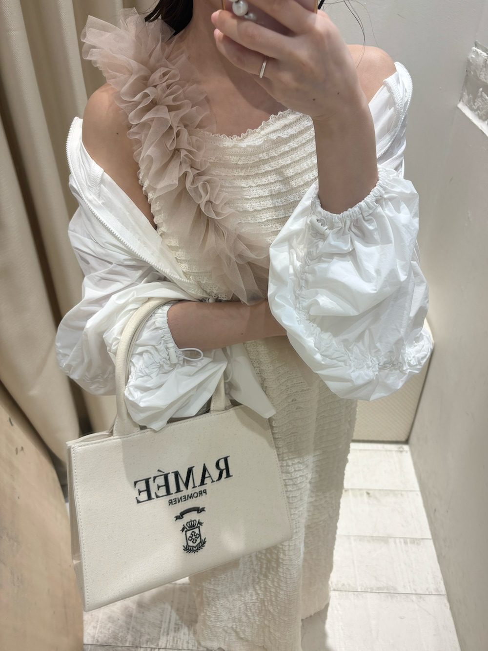 ホワイト系のワンピース、ホワイト系のマウンテンパーカー、ホワイト系のトートバッグを着用したレディースの春コーディネートの3枚目の写真