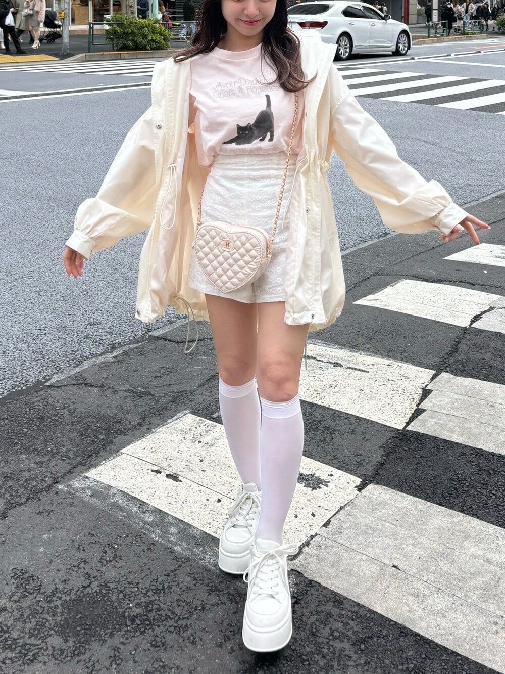 ピンク系のTシャツ/カットソー、ホワイト系のマウンテンパーカー、ピンク系のショルダーバッグを着用したレディースの春コーディネートの2枚目の写真