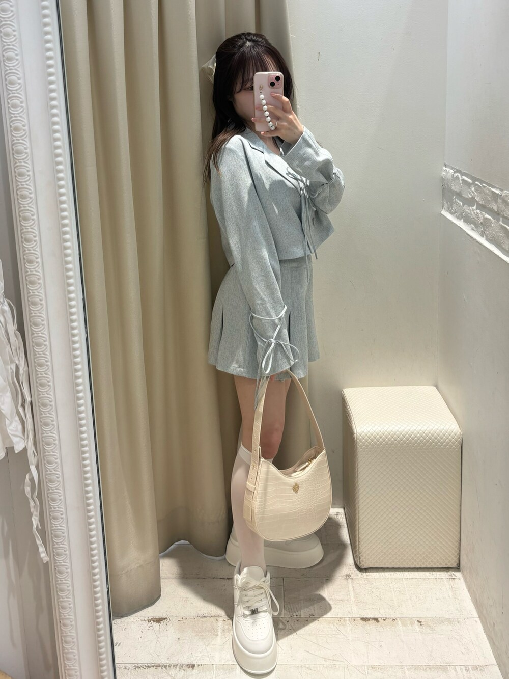 ブルー系のテーラードジャケット、ブルー系のスカート、ホワイト系のショルダーバッグを着用したレディースの春コーディネートの2枚目の写真