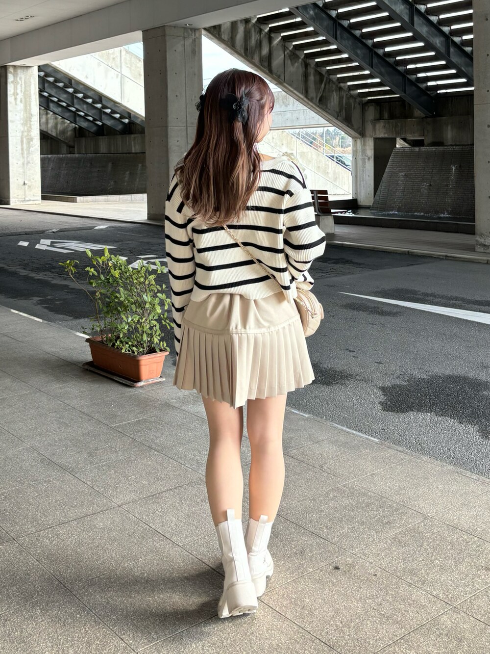 ホワイト系のキャミソール、ホワイト系のカーディガン/ボレロ、ベージュ系のスカートを着用したレディースの冬コーディネートの2枚目の写真