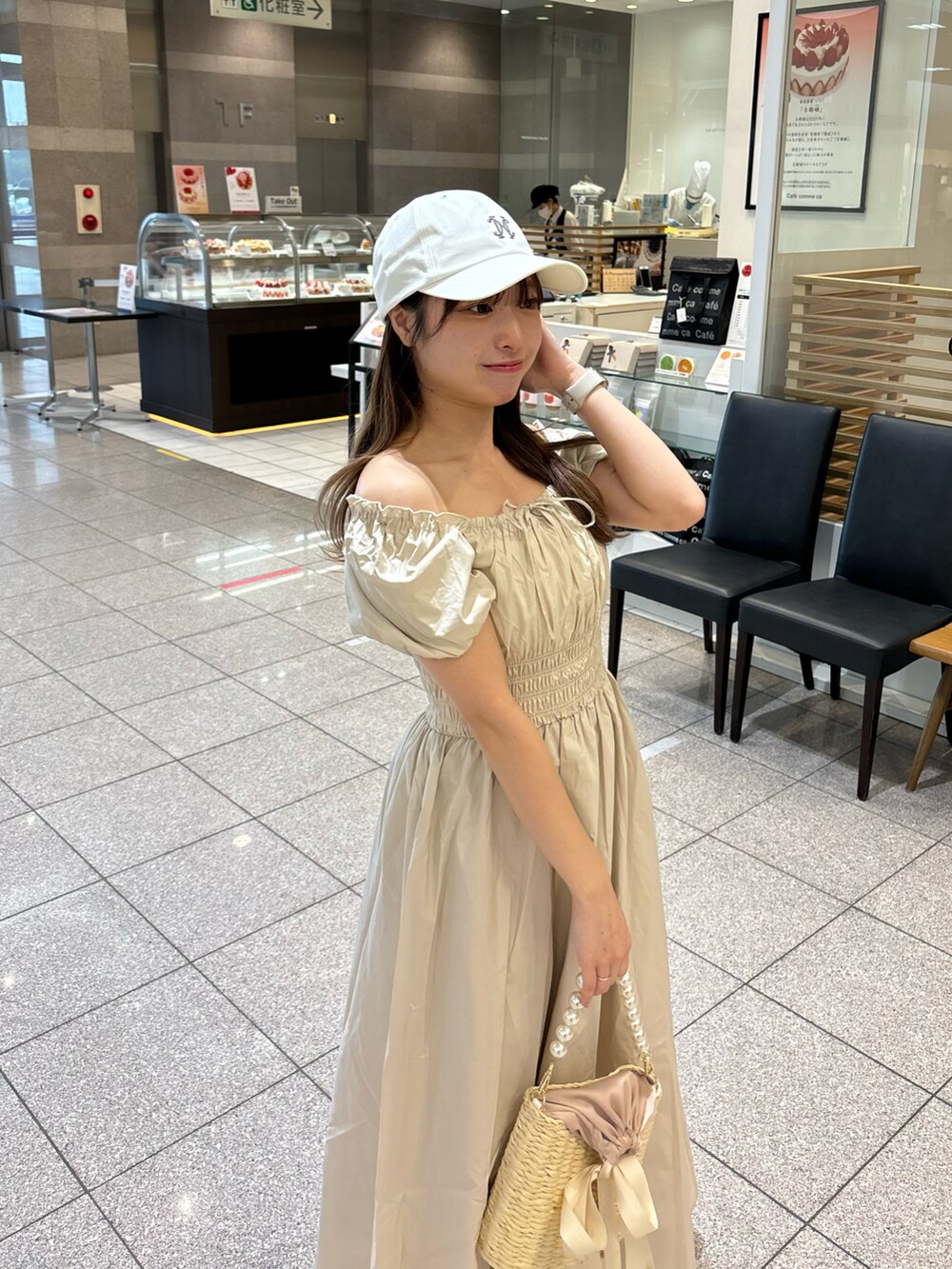 ベージュ系のワンピース、ホワイト系のかごバッグを着用したレディースの春コーディネートの3枚目の写真