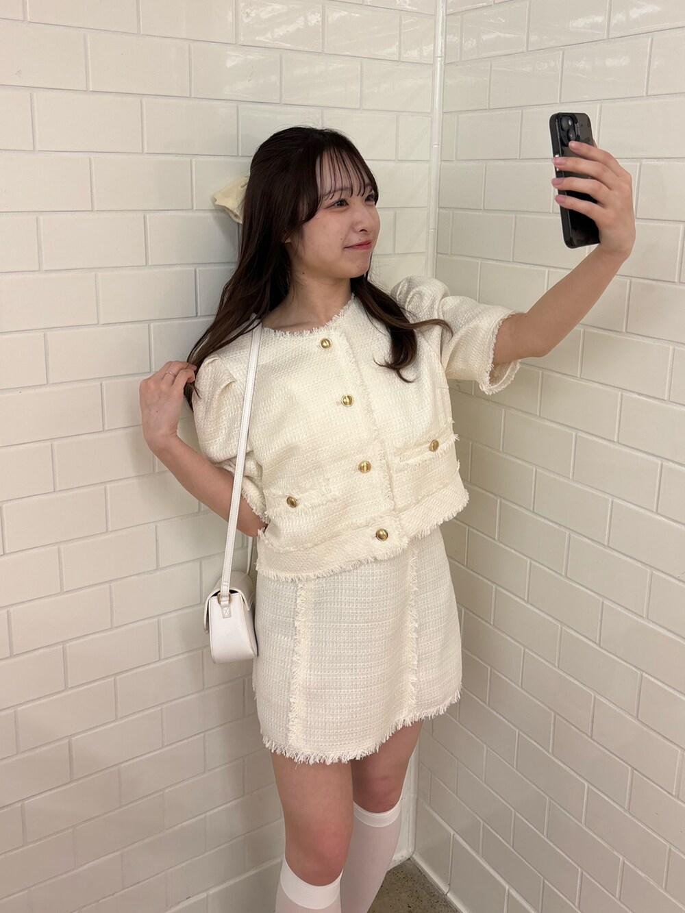 ホワイト系のテーラードジャケット、ホワイト系のスカート、ブラック系のローファーを着用したレディースの春コーディネートの3枚目の写真