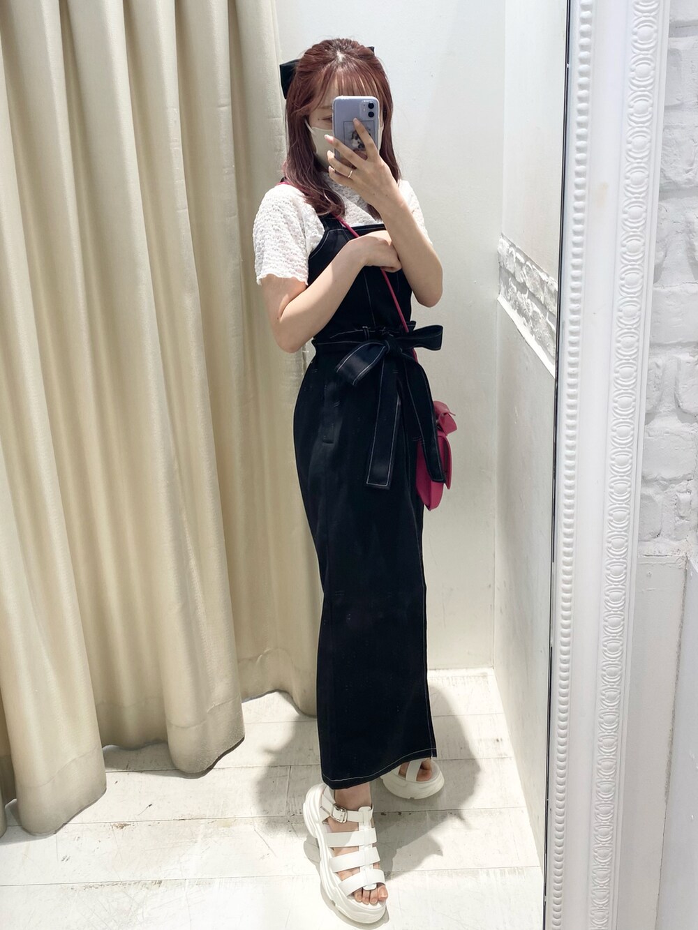 ホワイト系のサンダル、ブラック系のジャンパースカート、ピンク系のショルダーバッグを着用したレディースの夏コーディネートの2枚目の写真