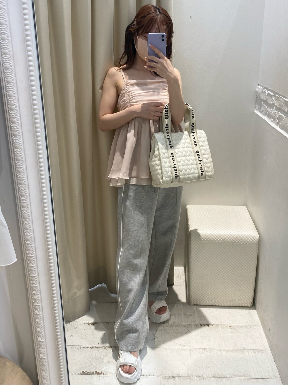 ピンク系のキャミソール、グレー系のスウェットパンツ、ホワイト系のトートバッグを着用したレディースの夏コーディネートの2枚目の写真