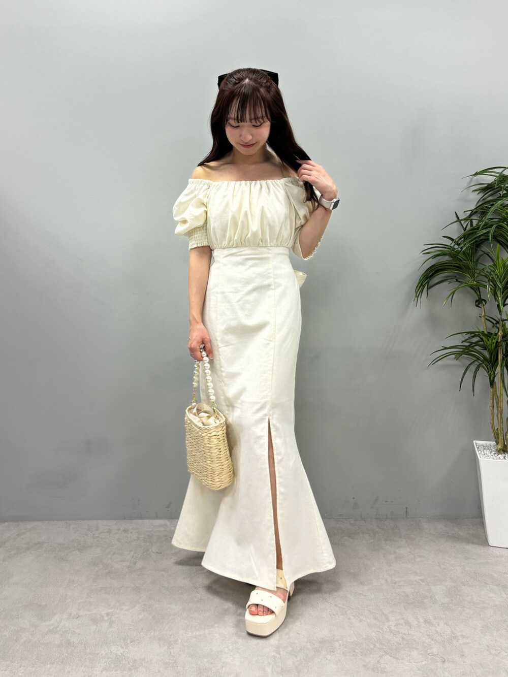 ホワイト系のワンピース、ホワイト系のサンダル、ホワイト系のかごバッグを着用したレディースの春コーディネートの3枚目の写真