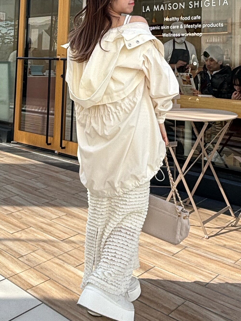 ホワイト系のマウンテンパーカーを着用したレディースの春コーディネートの2枚目の写真