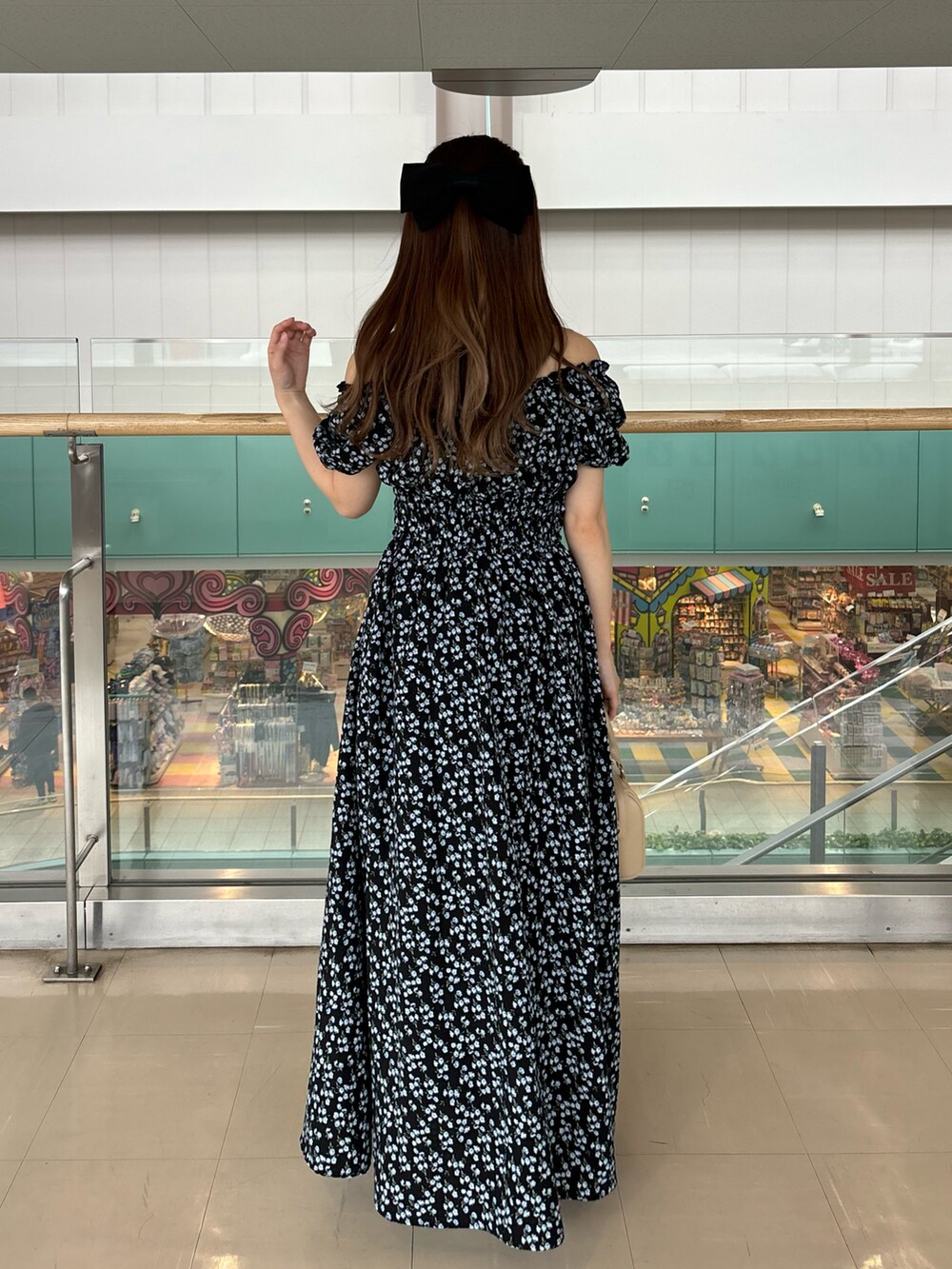 ブラック系のワンピース/ドレス、ベージュ系のボストンバッグ、ホワイト系のスニーカーを着用したレディースの春コーディネートの3枚目の写真