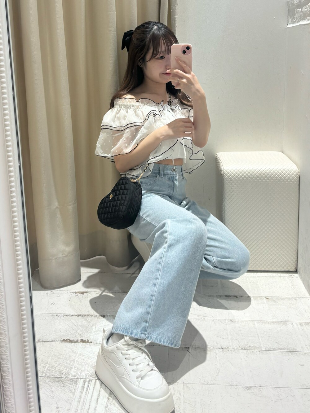 ブラック系のワンピース、ブラック系のショルダーバッグ、ブルー系のデニムパンツを着用したレディースの春コーディネートの3枚目の写真