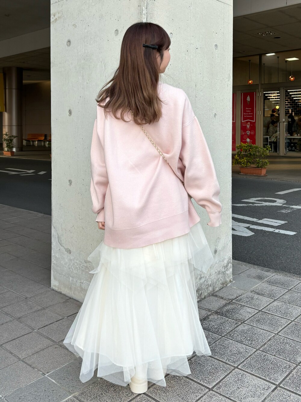 ピンク系のニット/セーター、ホワイト系のスカートを着用したレディースの冬コーディネートの2枚目の写真