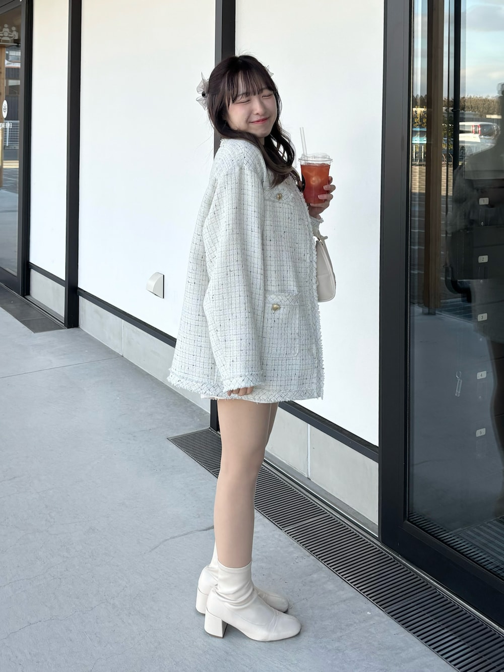 ホワイト系のノーカラージャケット、ホワイト系のその他パンツ、ホワイト系のハンドバッグを着用したレディースの冬コーディネートの3枚目の写真