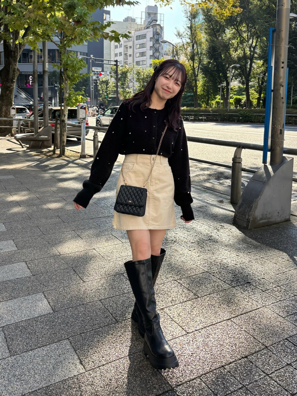 ブラック系のニット/セーター、ホワイト系のスカートを着用したレディースの秋コーディネートの2枚目の写真