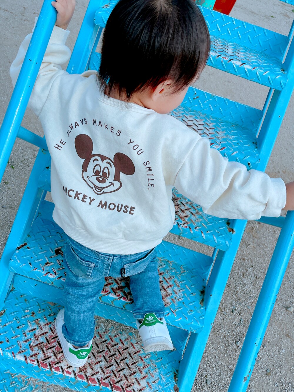 ホワイト系のトップス、ブルー系のデニムパンツ、ホワイト系のスニーカーを着用したキッズの春コーディネートの2枚目の写真