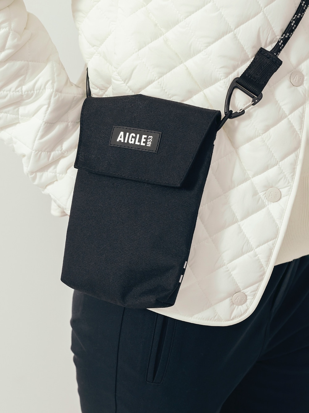 ブラック系のレインシューズ、ブラック系のショルダーバッグ、ブラック系のその他パンツを着用したレディースの冬コーディネートの5枚目の写真