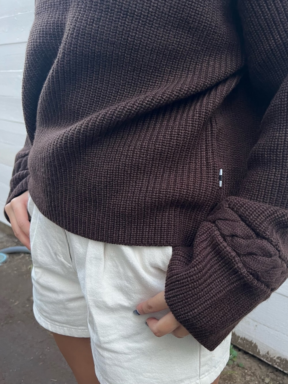 ブラウン系のニット/セーター、グリーン系のダウンジャケット/コートを着用したレディースの秋コーディネートの4枚目の写真