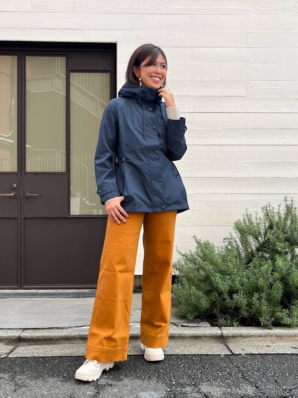 オレンジ系のその他パンツ、ホワイト系のスニーカー、ホワイト系のTシャツ/カットソーを着用したレディースの秋コーディネートの2枚目の写真