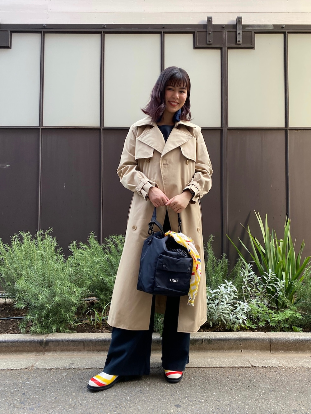 ブラック系のその他パンツ、ブラック系のショルダーバッグ、ベージュ系のトレンチコートを着用したレディースの春コーディネートの2枚目の写真
