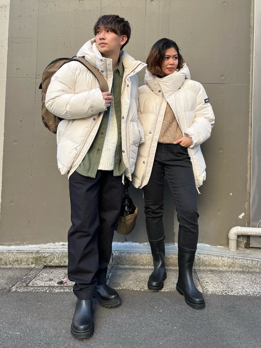 ブラック系のデニムパンツ、ベージュ系のニット/セーター、ブラック系のレインシューズを着用したレディースの冬コーディネートの2枚目の写真