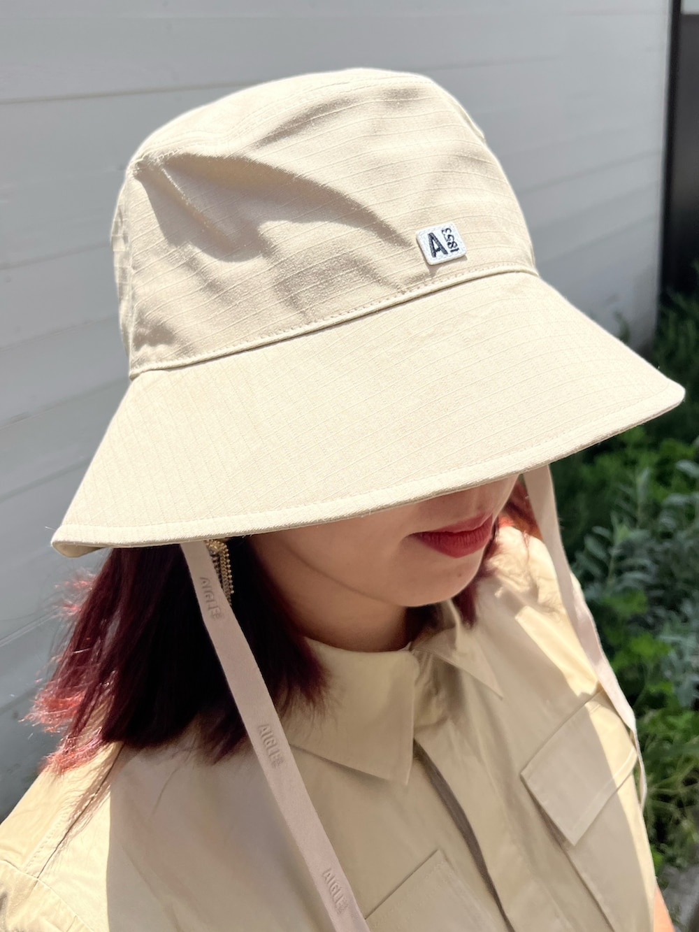 グリーン系のその他パンツ、ブラック系のレインシューズ、ベージュ系のシャツ/ブラウスを着用したレディースの夏コーディネートの4枚目の写真