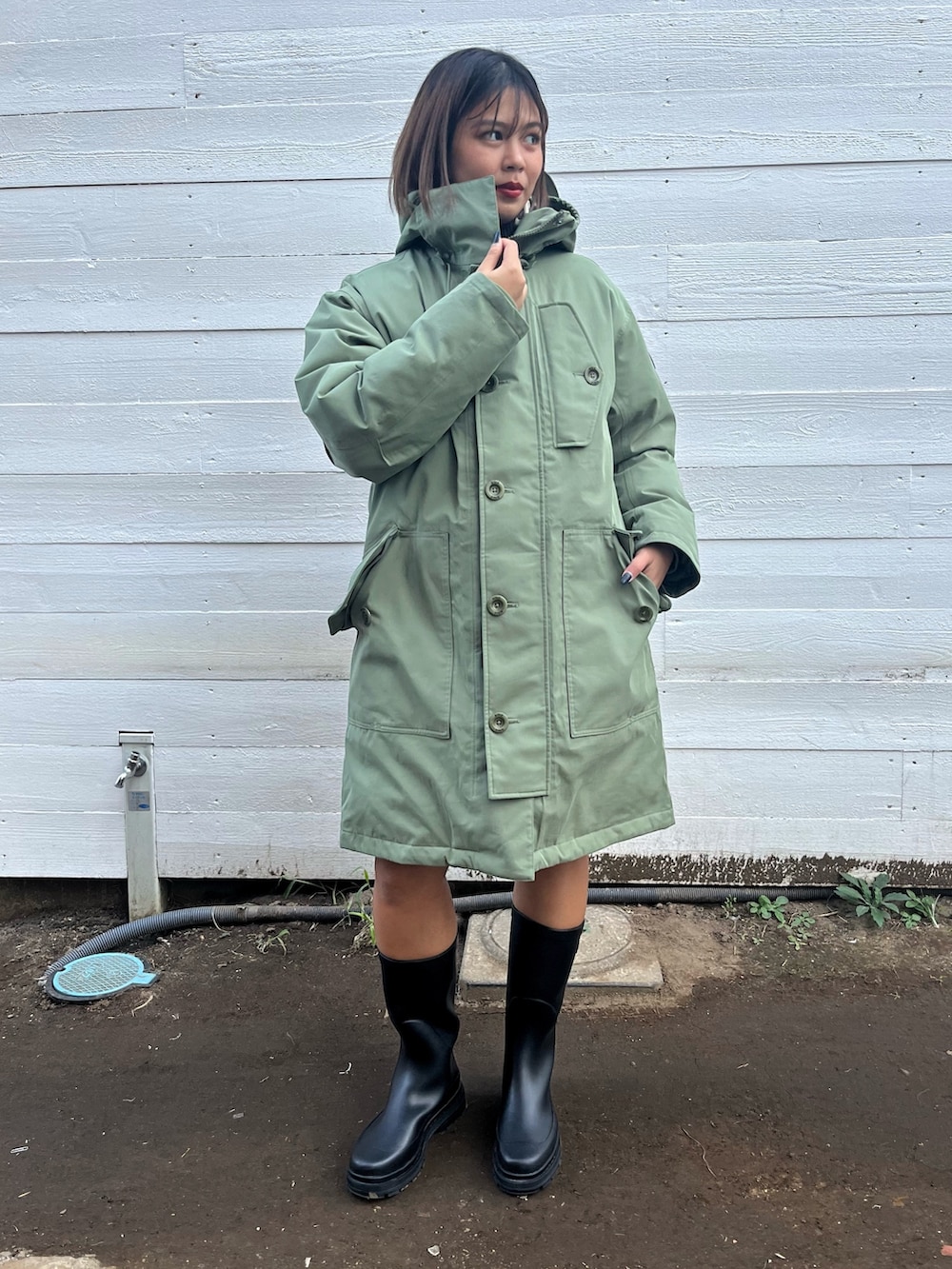 ブラウン系のニット/セーター、グリーン系のダウンジャケット/コートを着用したレディースの秋コーディネートの2枚目の写真