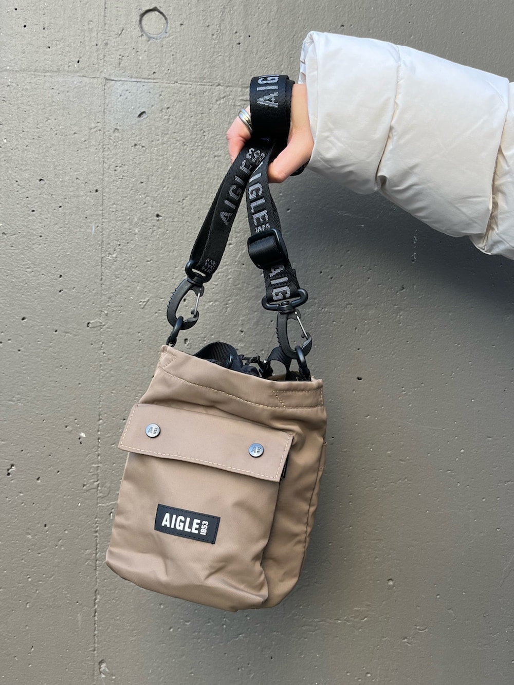 ブラック系のデニムパンツ、ベージュ系のニット/セーター、ブラック系のレインシューズを着用したレディースの冬コーディネートの4枚目の写真