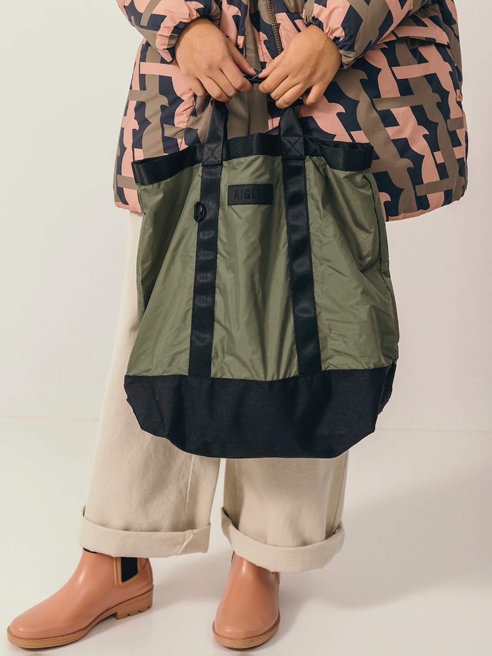 グリーン系のTシャツ/カットソー、ホワイト系のその他パンツ、ピンク系のレインシューズを着用したレディースの冬コーディネートの4枚目の写真